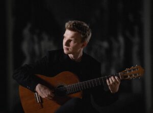 Mateusz Kowalski grający na gitarze